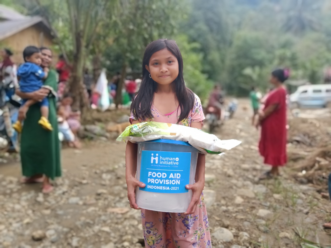 Girl in Indonesia holding food aid provision